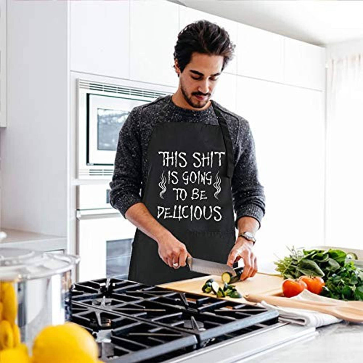 Black chef BBQ apron with funny slogan, worn by man cooking at an outdoor grill