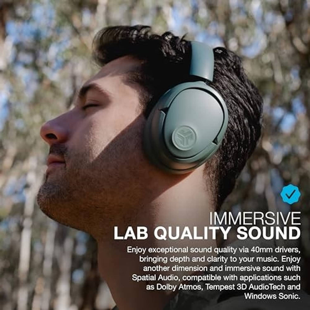 Sage green over-ear headphones on a person, side profile outdoors