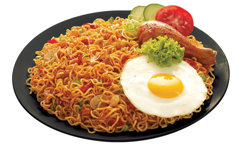 Stir-fried Mi goreng noodles with fried egg, tomato slice, and lettuce garnish