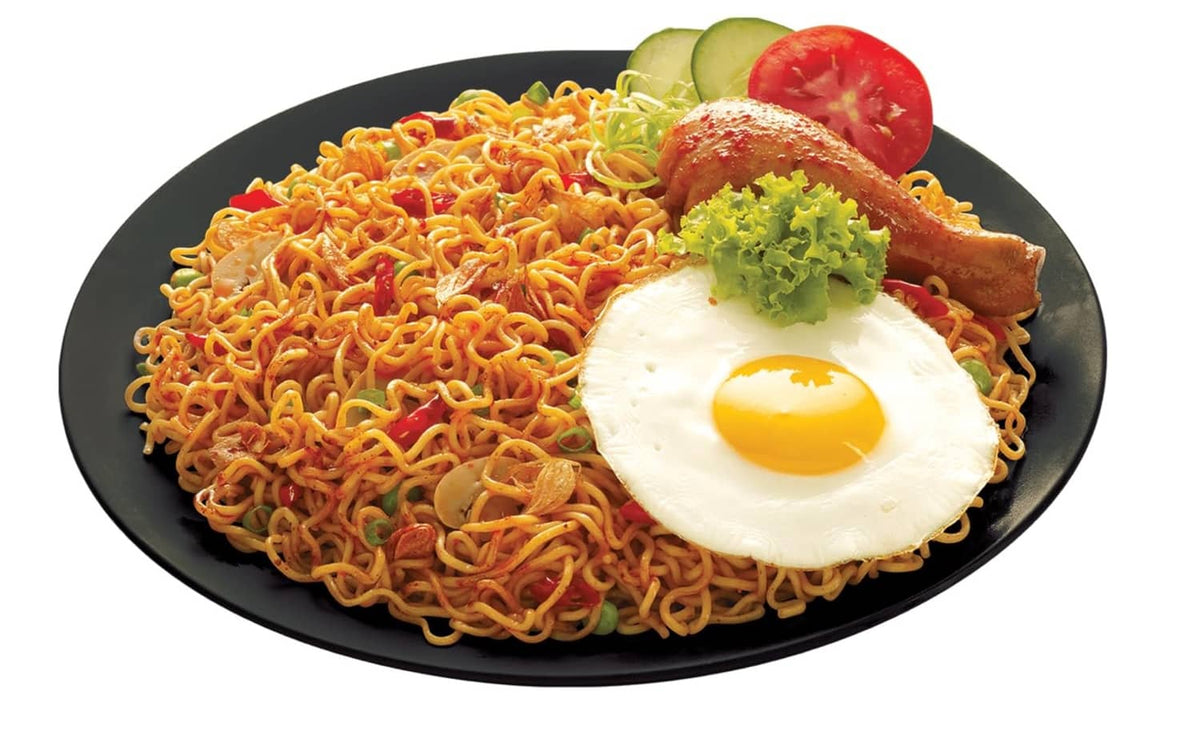 Stir-fried Mi goreng noodles with fried egg, tomato slice, and lettuce garnish