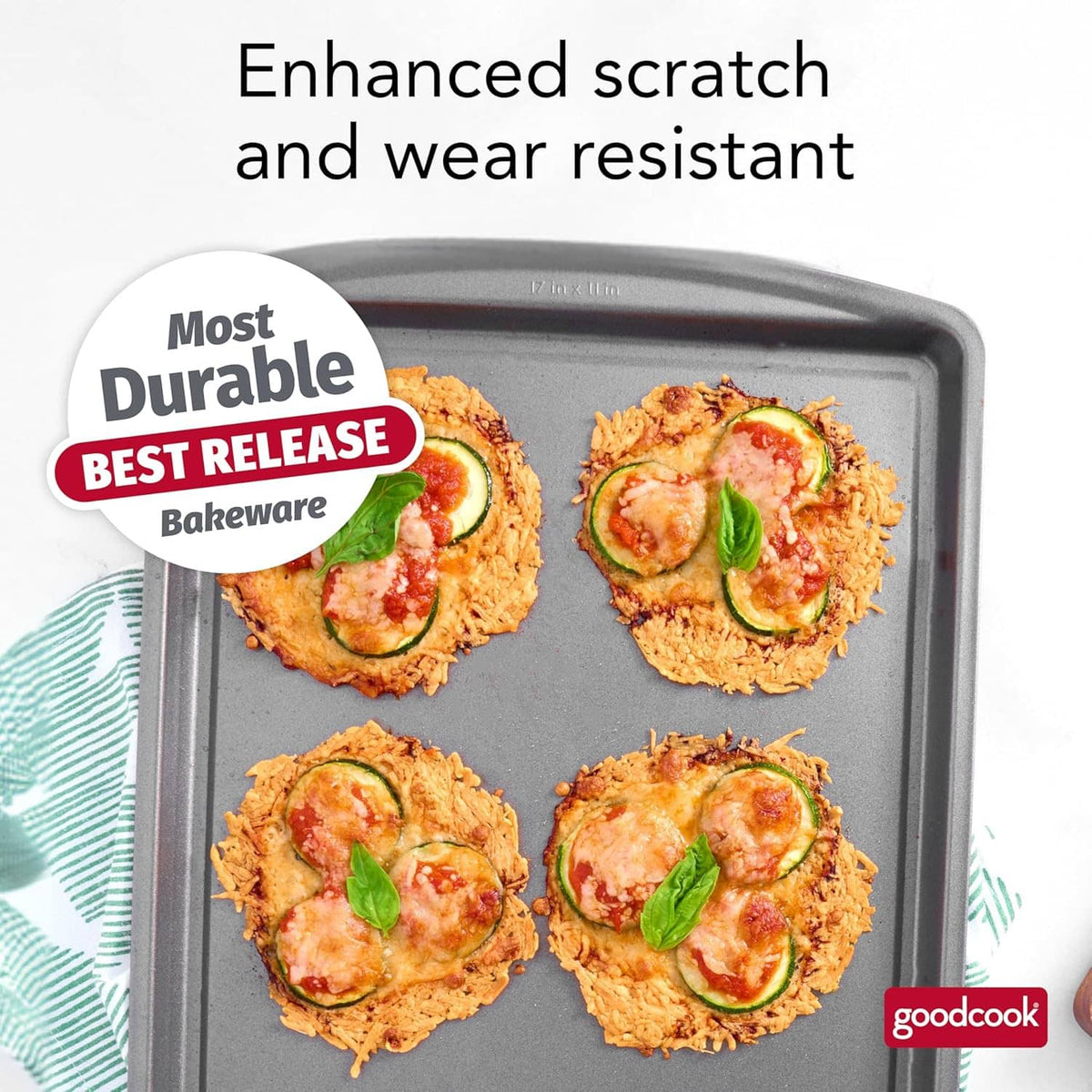 Gray nonstick baking sheet with four baked cookies topped with herbs