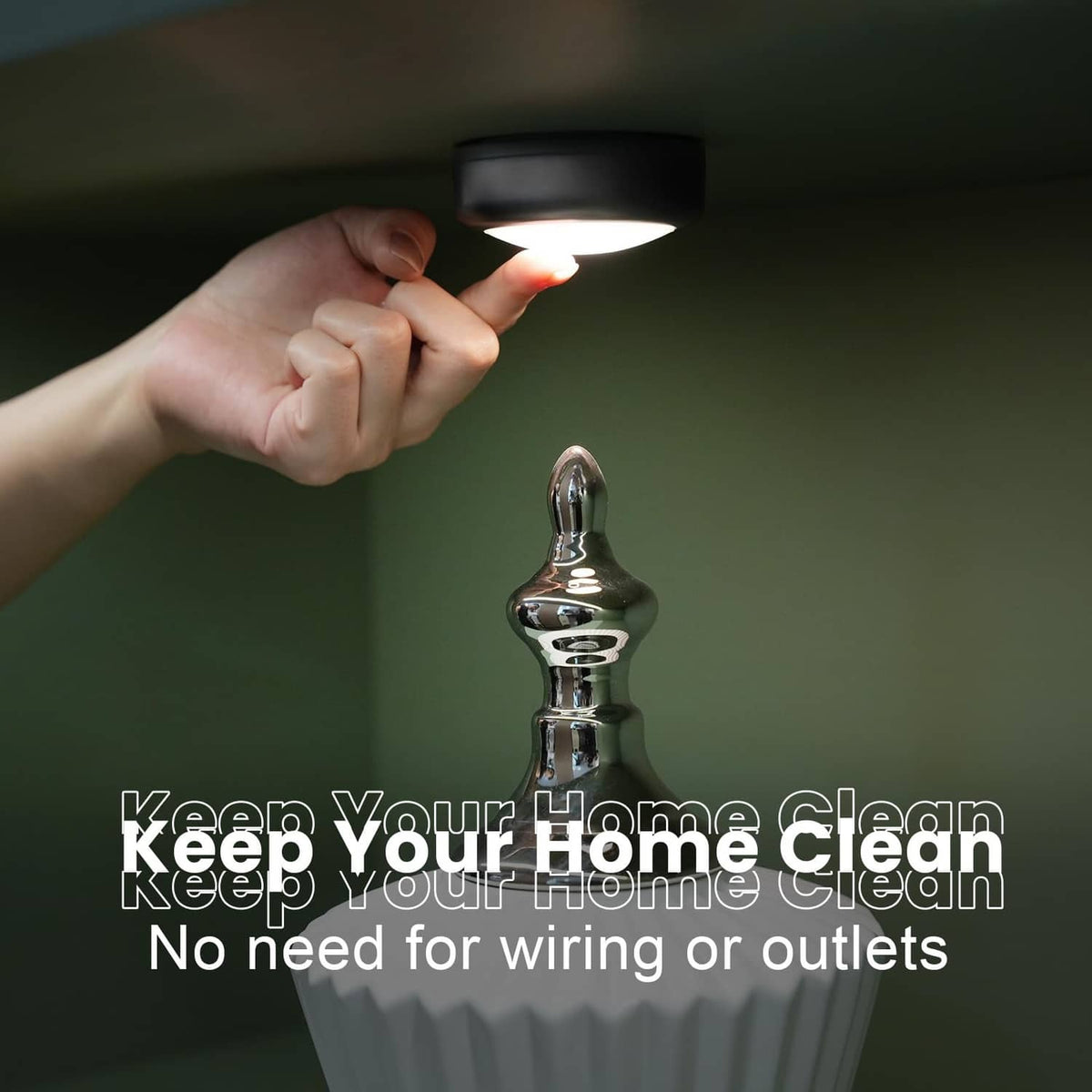 Hand pressing battery LED puck light switch; warm white ceiling glow