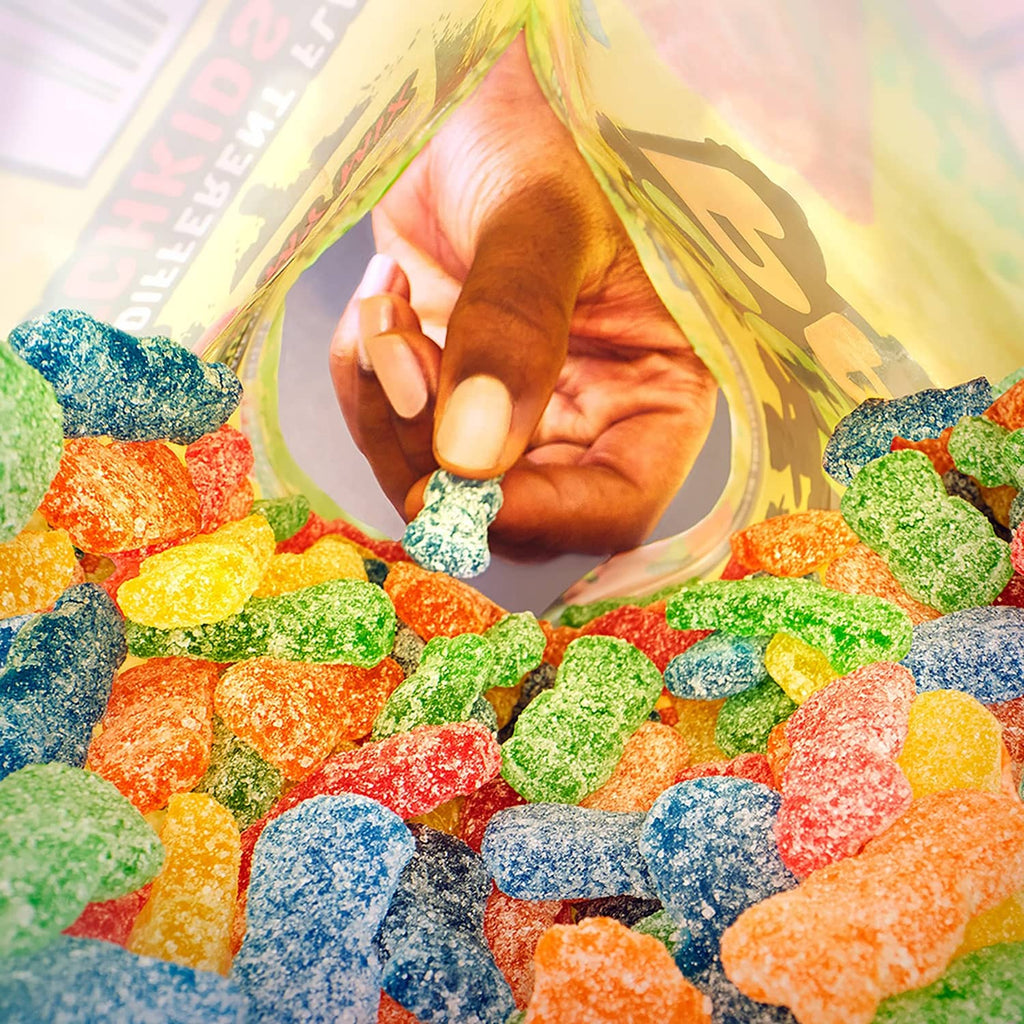 Colorful assortment of sour candy pieces scattered around a child figure in the background