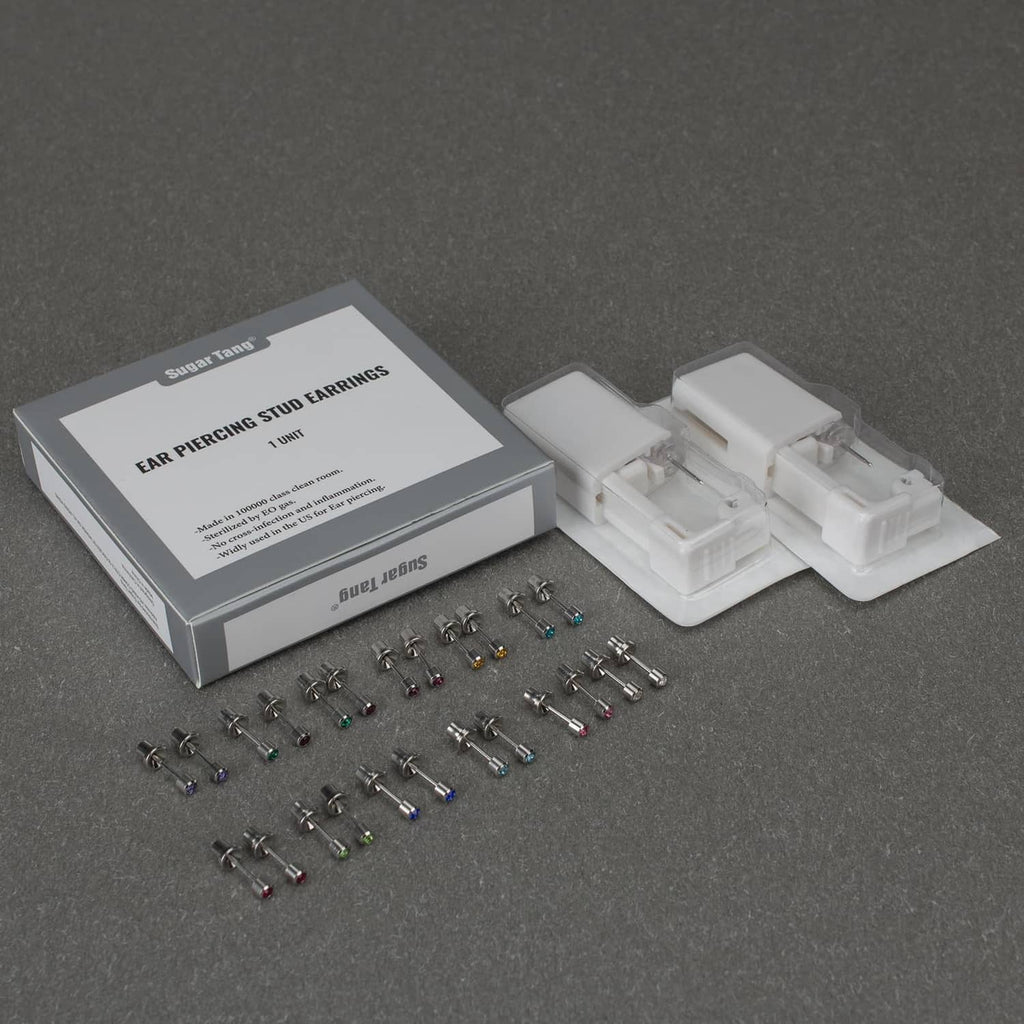 Ear piercing kit box with loose stud earrings and disposable gun cartridge pieces