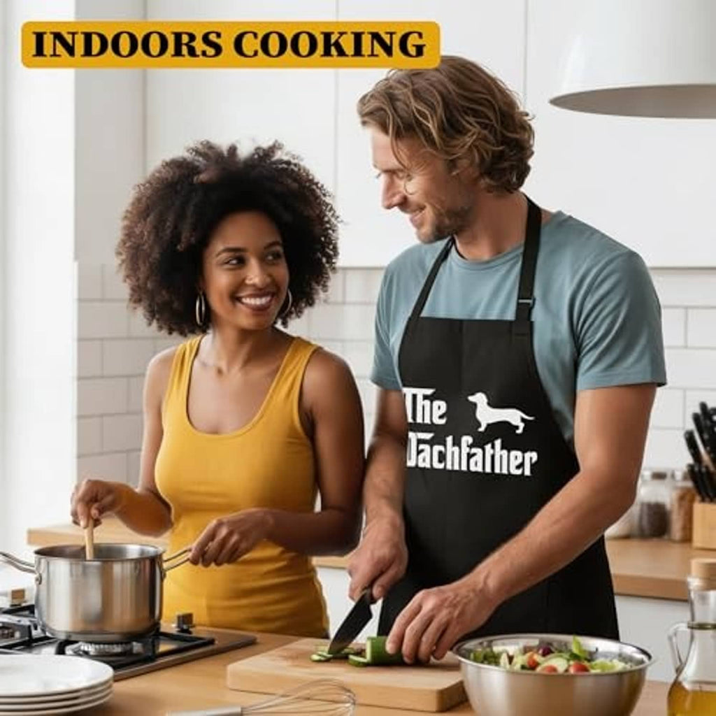Black apron with Dachfather dog graphic worn by a man during cooking.