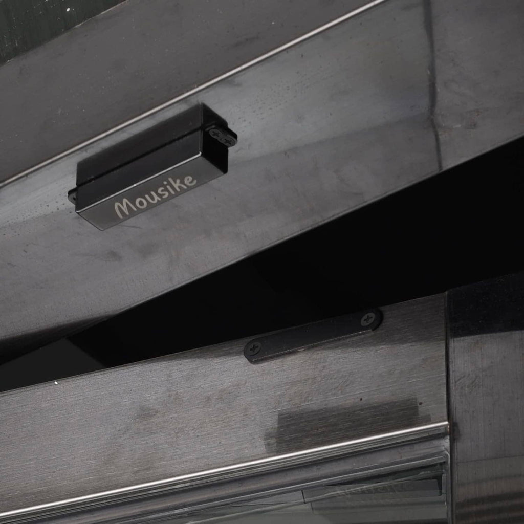 Black magnetic door catch on cabinet frame with latch bar and screws