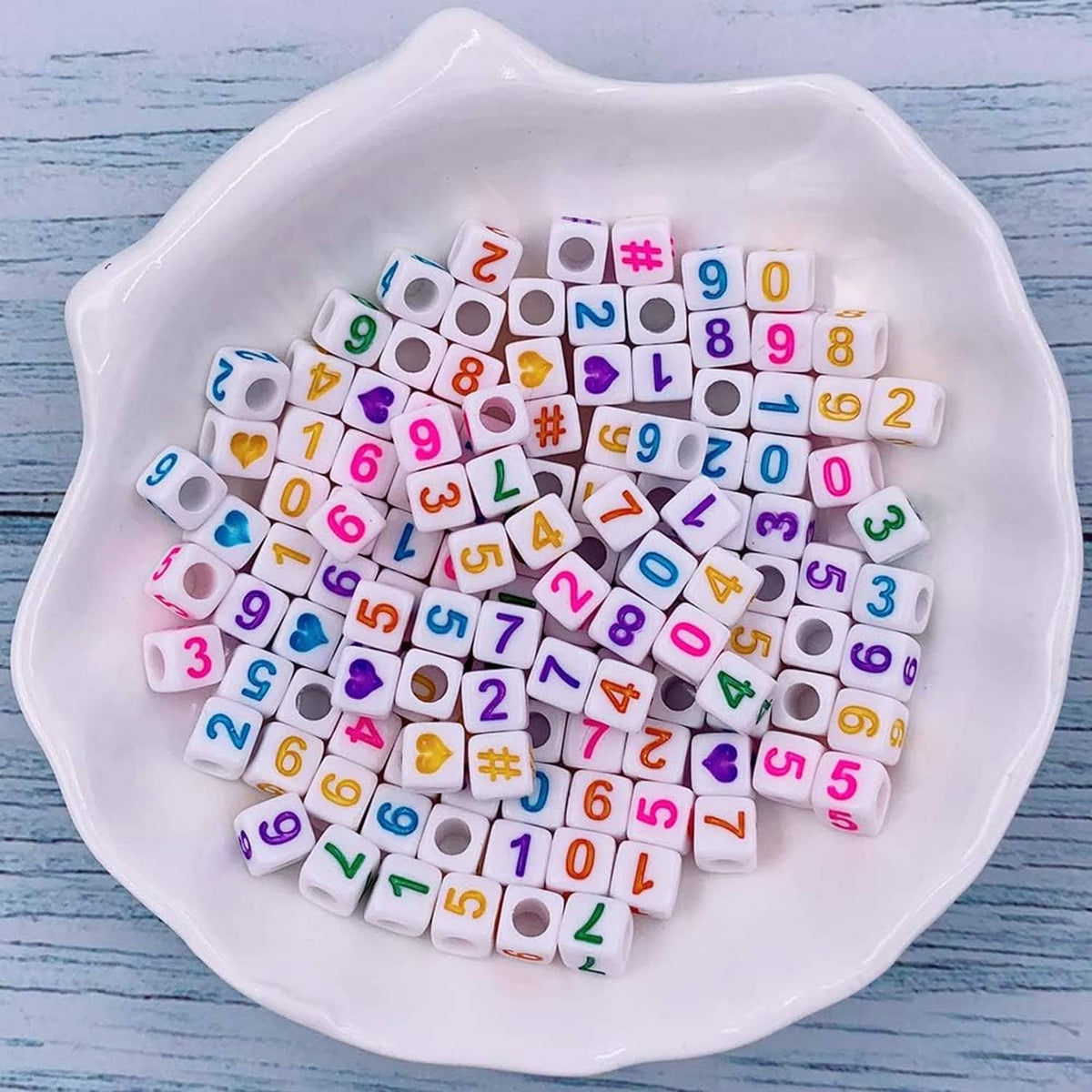 White tray of mixed alphabet and number cube beads in assorted colors