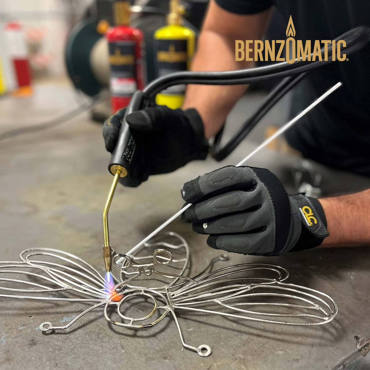 Aluminum brazing and welding rod tip in use with gloved hand on metal wires