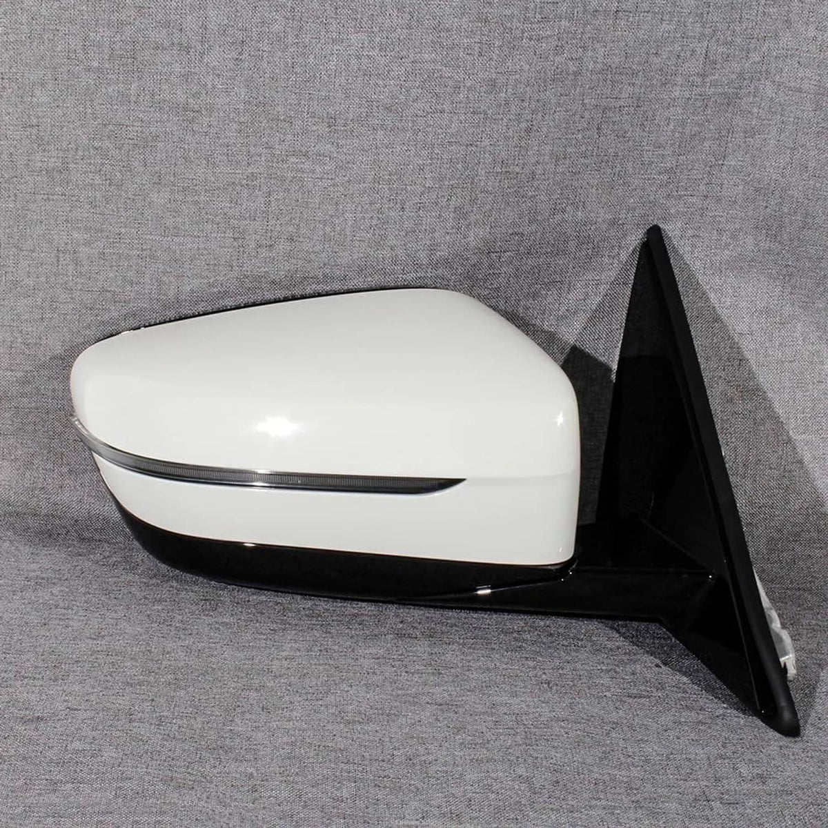 White passenger side mirror with black triangular back cover and reflective glass