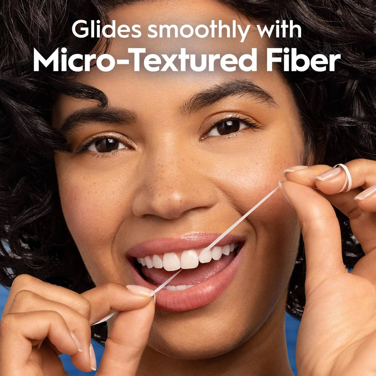 Person holding floss thread near smile, micro-textured fiber dental care