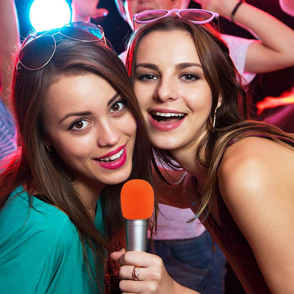 Orange foam microphone cover on handheld mic held by partygoers