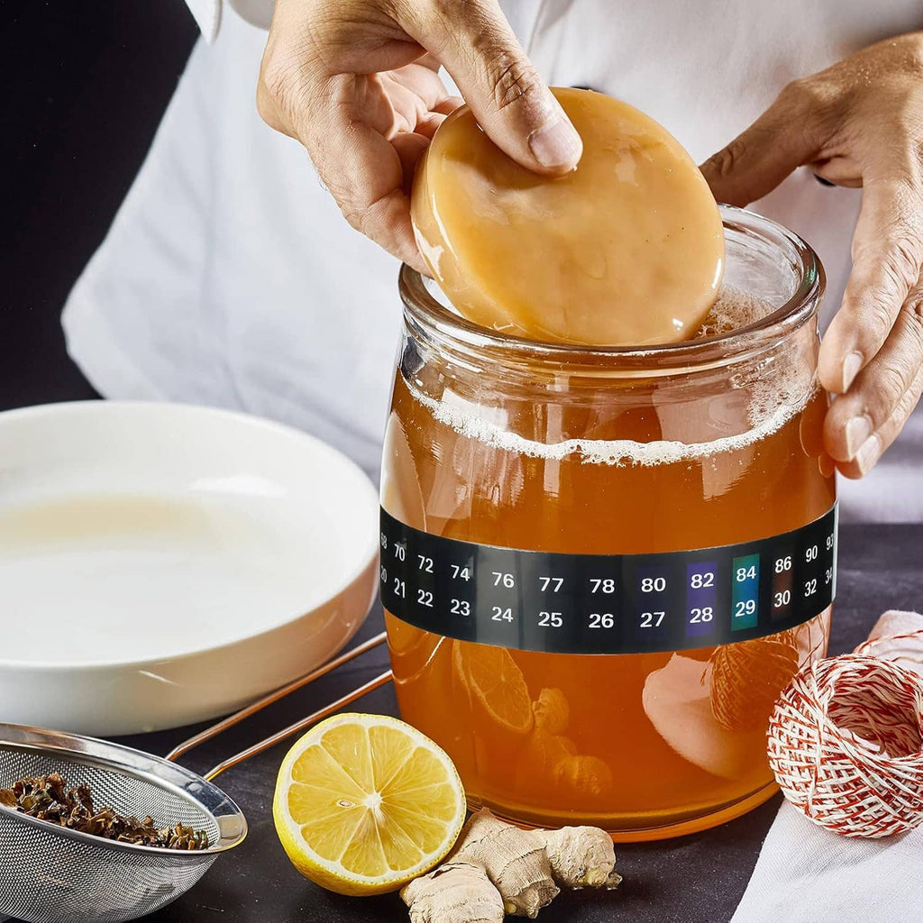 Black thermometer strip sticker with °F and °C scale wrapped around a drink jar.