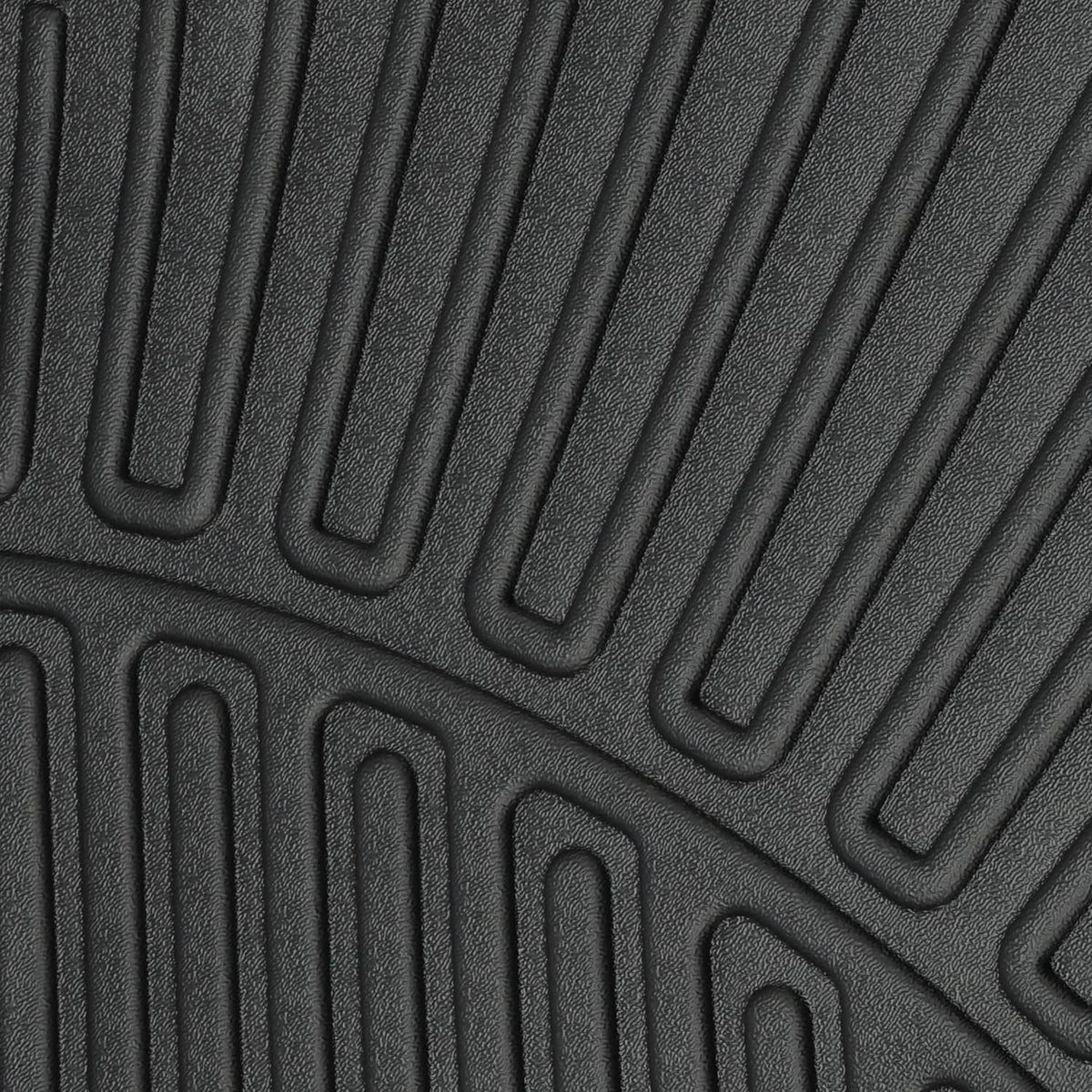 Close-up of black molded mat texture with parallel grooves and raised channel patterns.