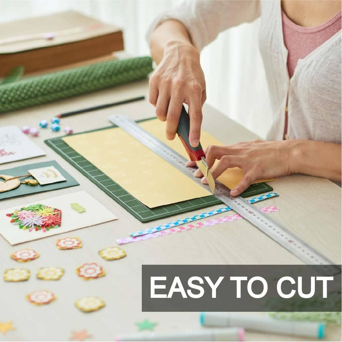 Cardboard sheet being cut with a craft knife