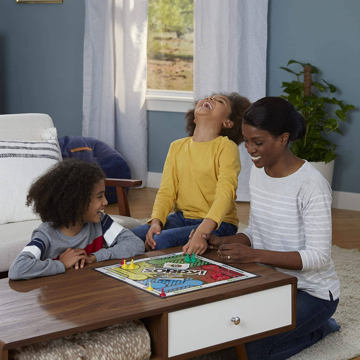 Family gathered around a table playing Sorry! board game