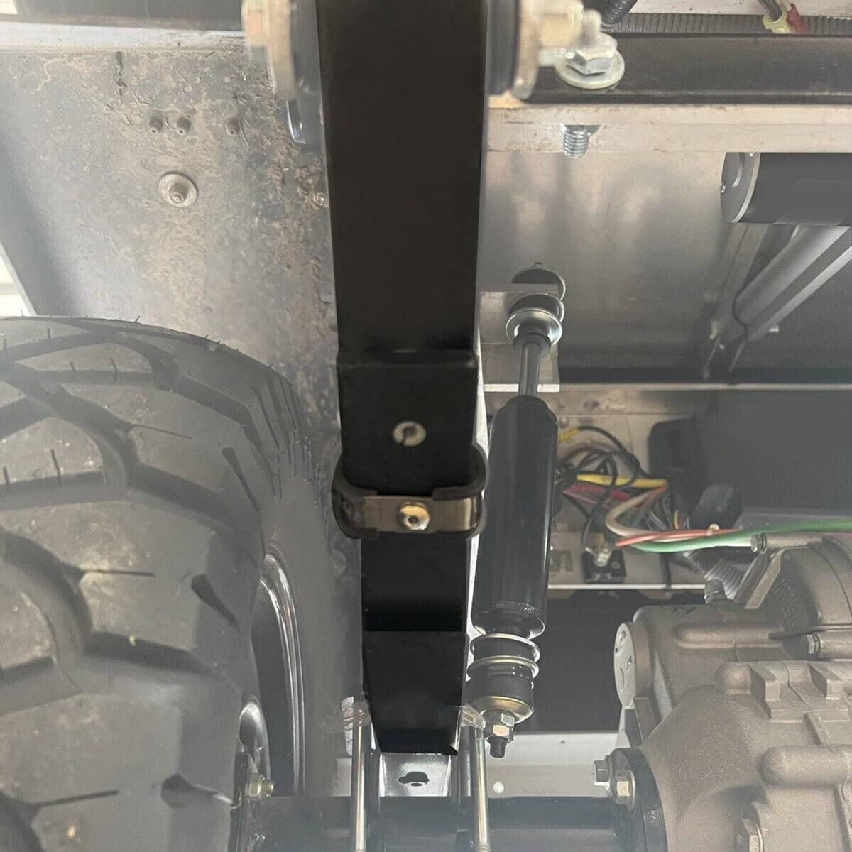 Rear leaf spring shock/strut mounting area with black springs and metal hardware