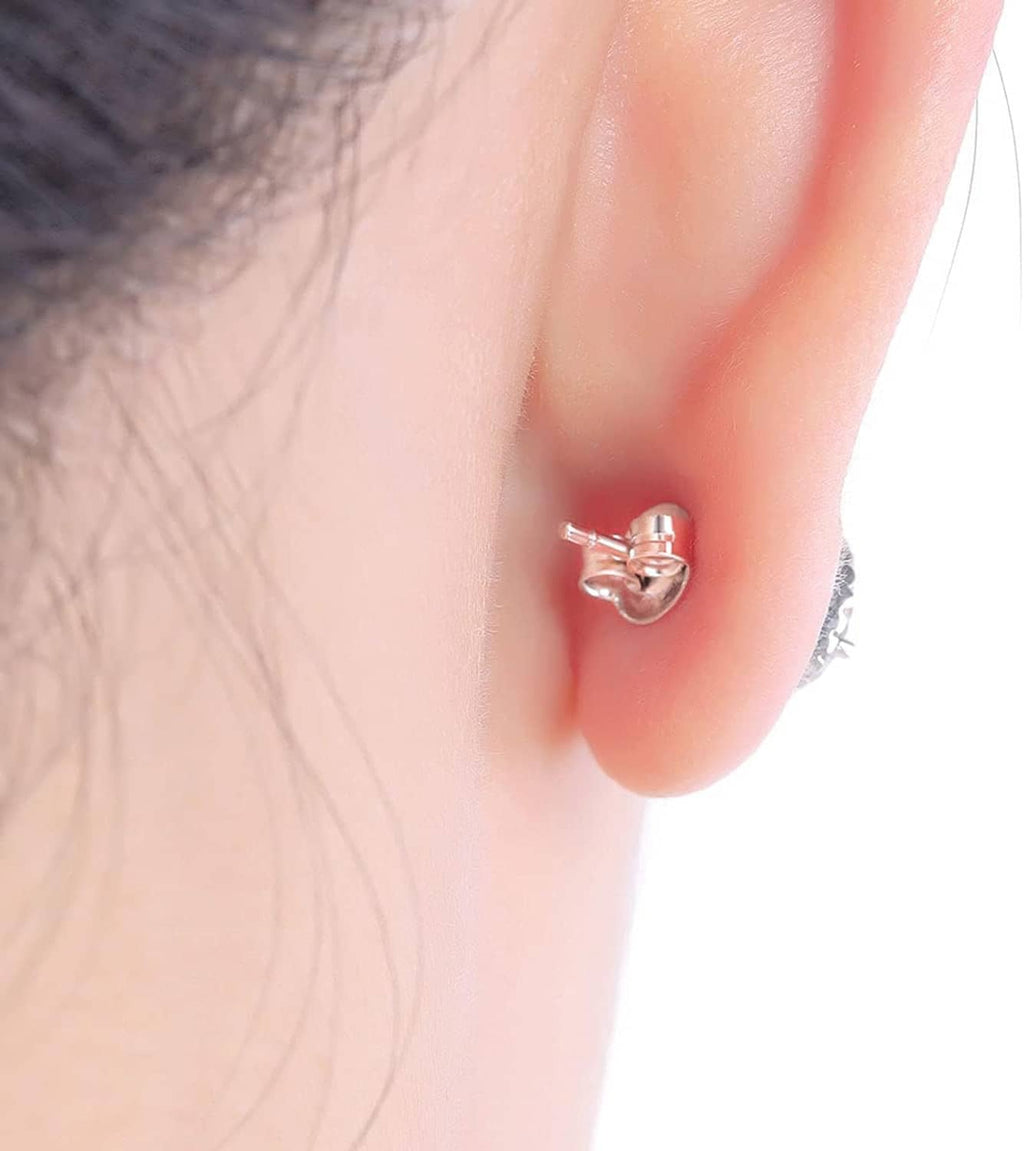 Gold-tone stud earring with round back on the earlobe