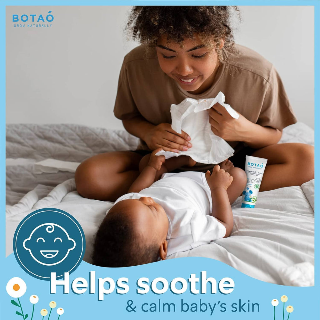 Diaper rash cream tube near a caregiver holding a baby, white tube with blue cap.