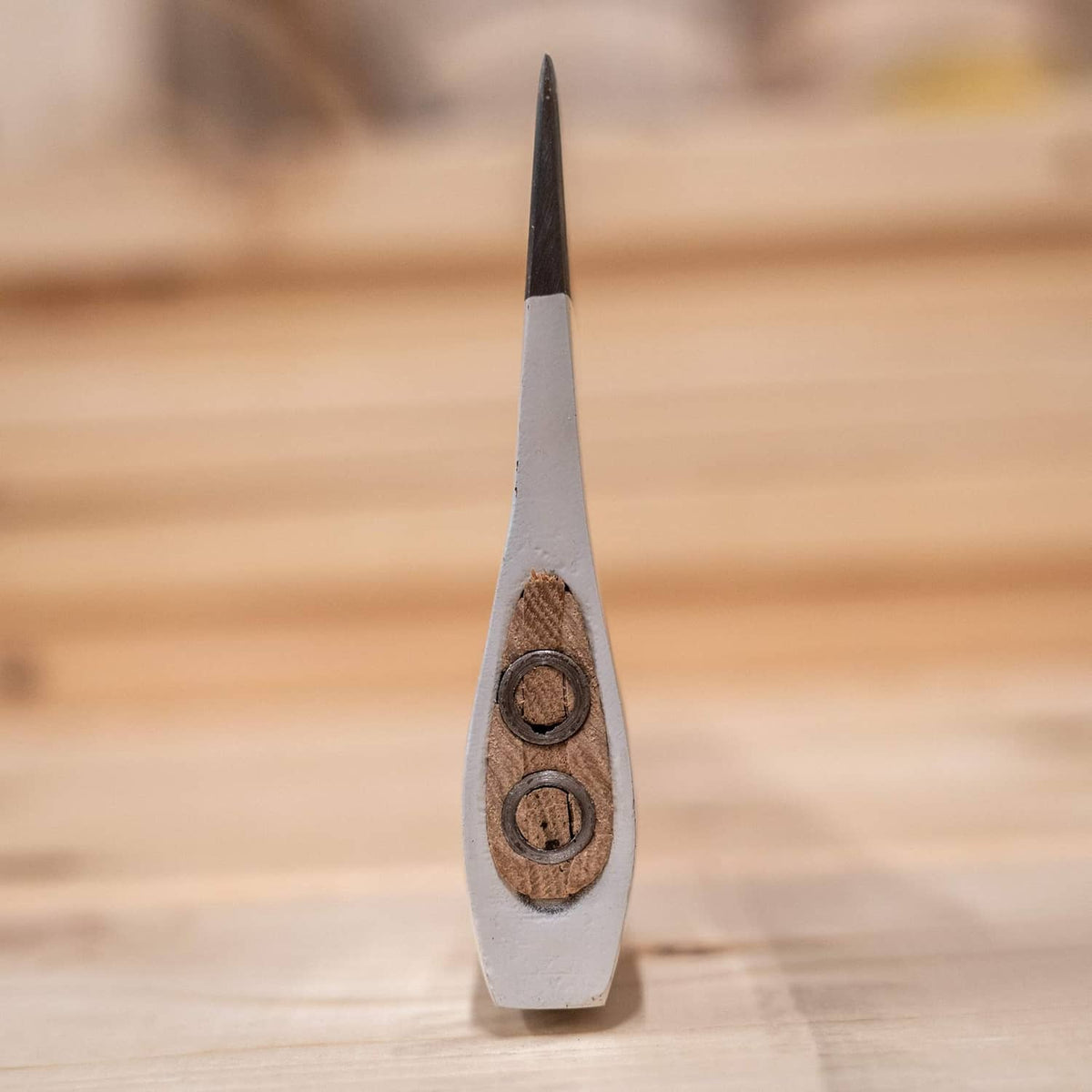 Axe head end view with two circular holes and dark steel blade