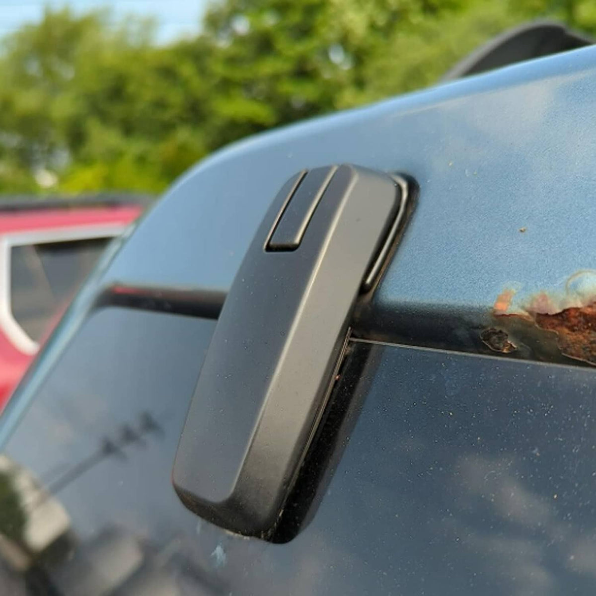 Black rear liftgate window hinge on glass hatch, side view close-up