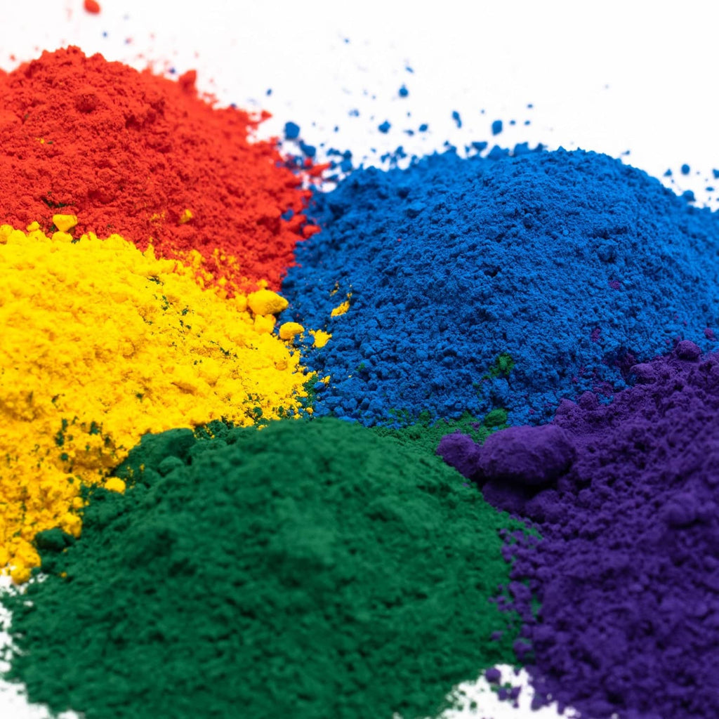 Iron oxide pigment powder granules in red, blue, yellow, green, and purple piles