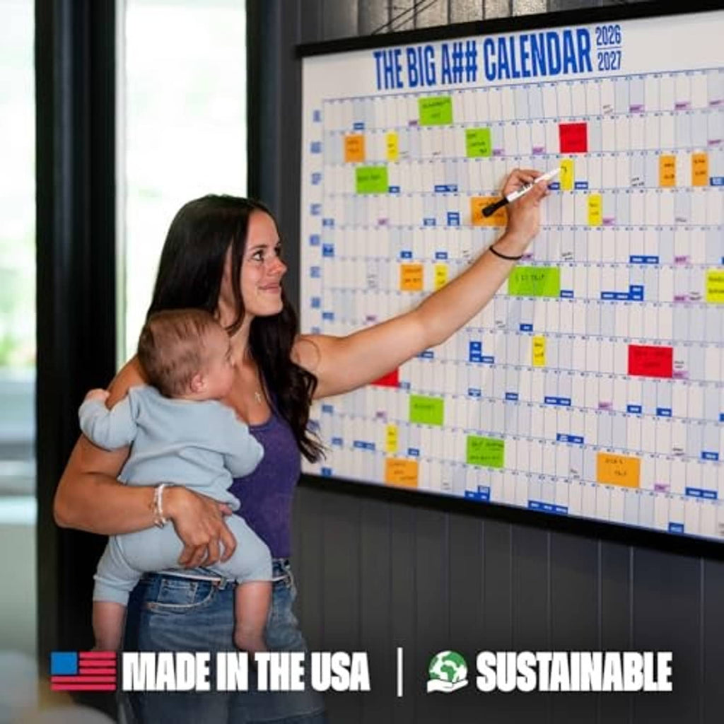 Dry-erase wall calendar with colorful blocks and date labels, person pointing to the grid