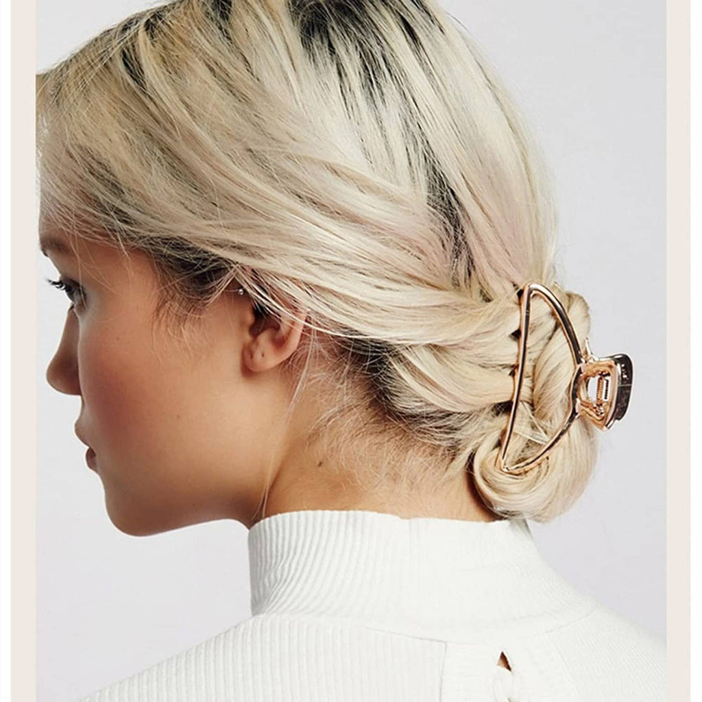 Rose-gold metal hair claw clip on blonde hair, side view with ridged grip