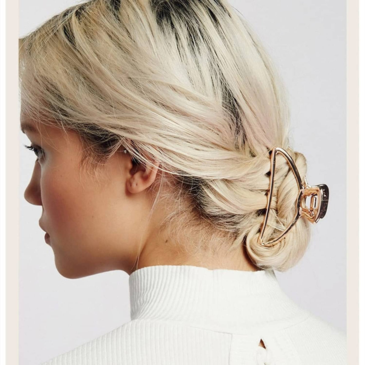 Rose-gold metal hair claw clip on blonde hair, side view with ridged grip