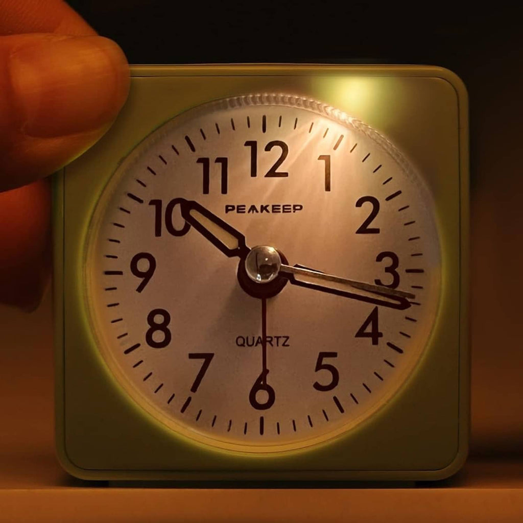Mint teal travel alarm clock with illuminated analog dial and quartz markings