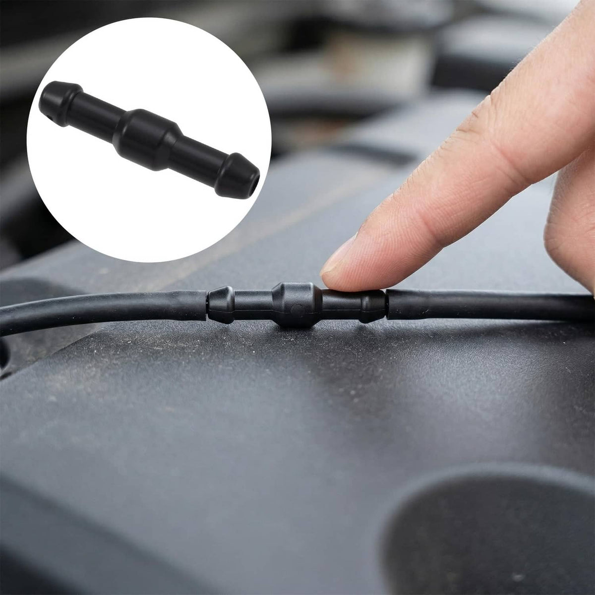 Black windshield washer hose with two-way connector joint held by fingers