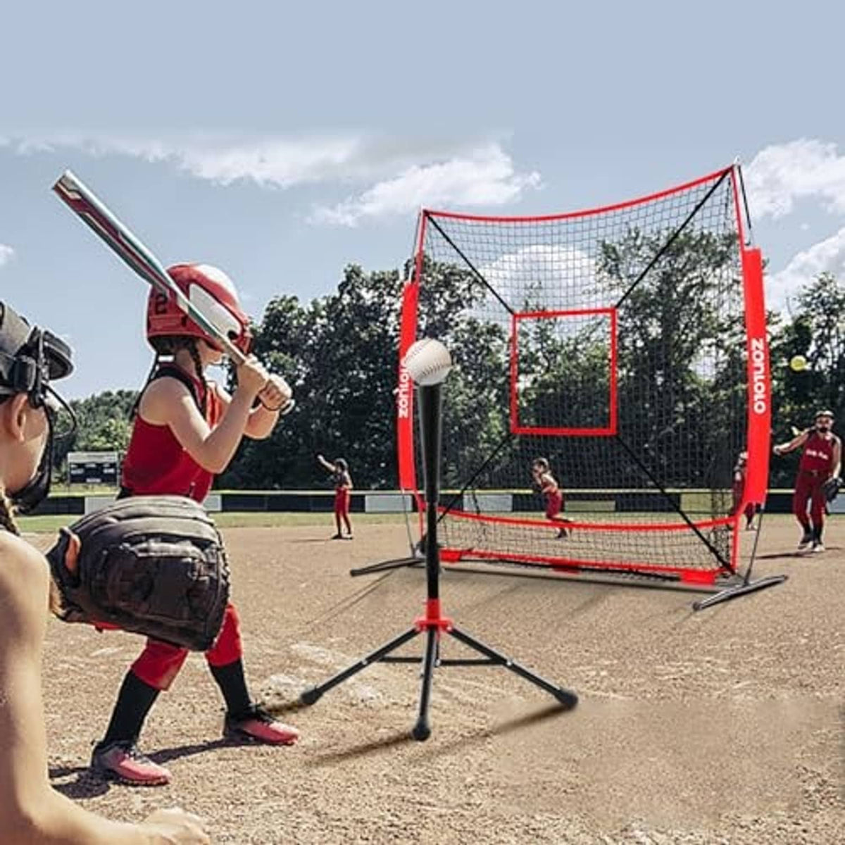 Outdoor baseball training net with red frame, tripod legs, and central strike target
