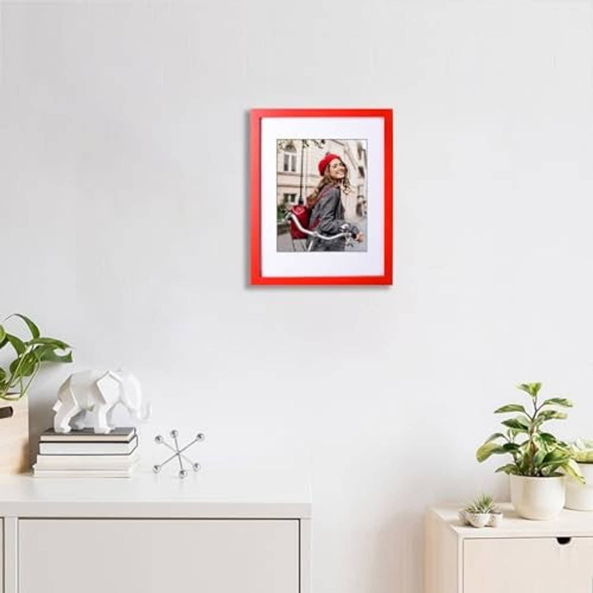 Small red solid wood picture frame on wall above console