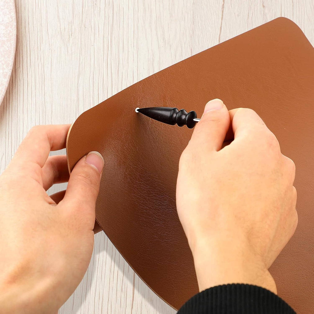 Leather edge burnishing tool: black bit pressing on brown leather sheet