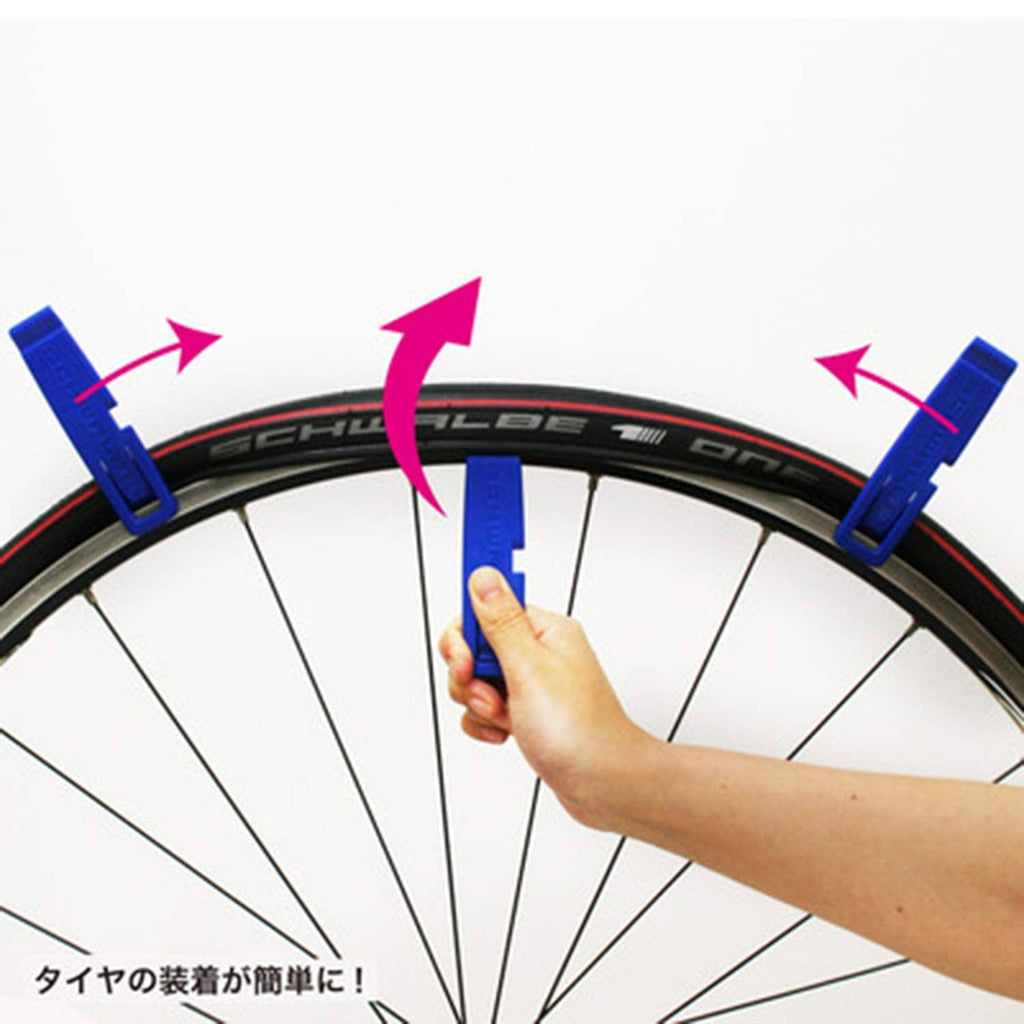 Blue tire levers placed on a bicycle wheel during tire installation
