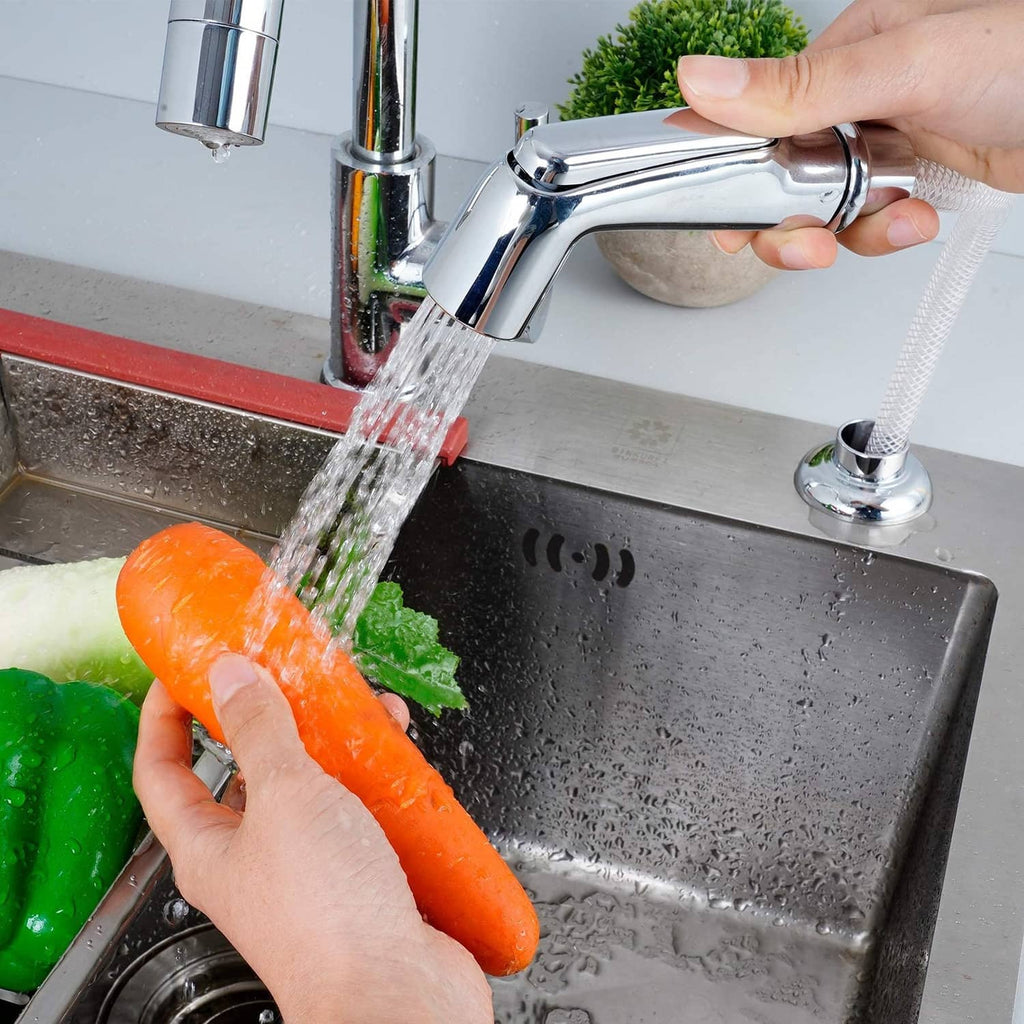 Chrome sink side sprayer faucet spraying water into a stainless sink