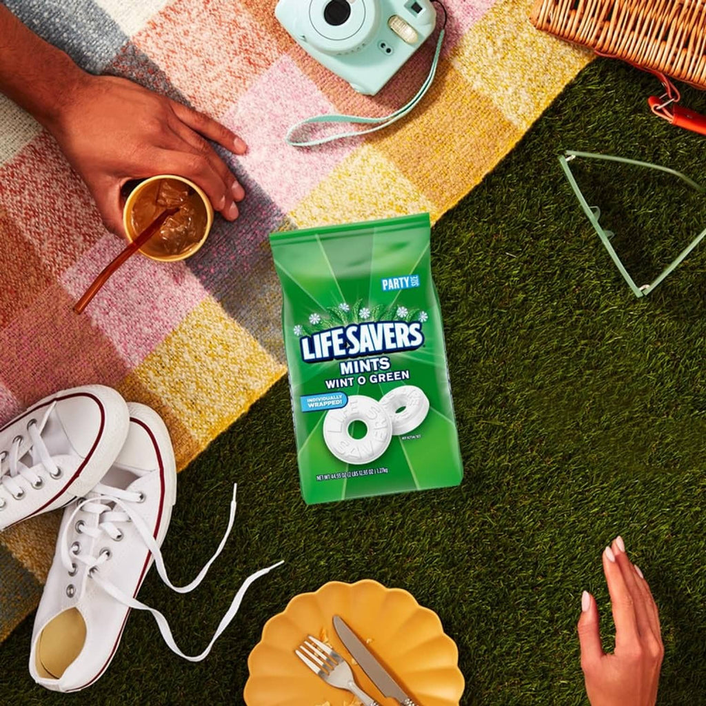 Green LIFE SAVERS mints pack on grass with white mint discs nearby