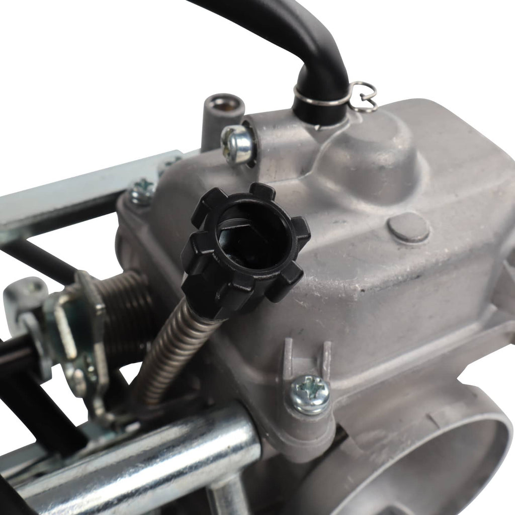 Carburetor detail with black vacuum port, metal housing, and threaded adjustment parts