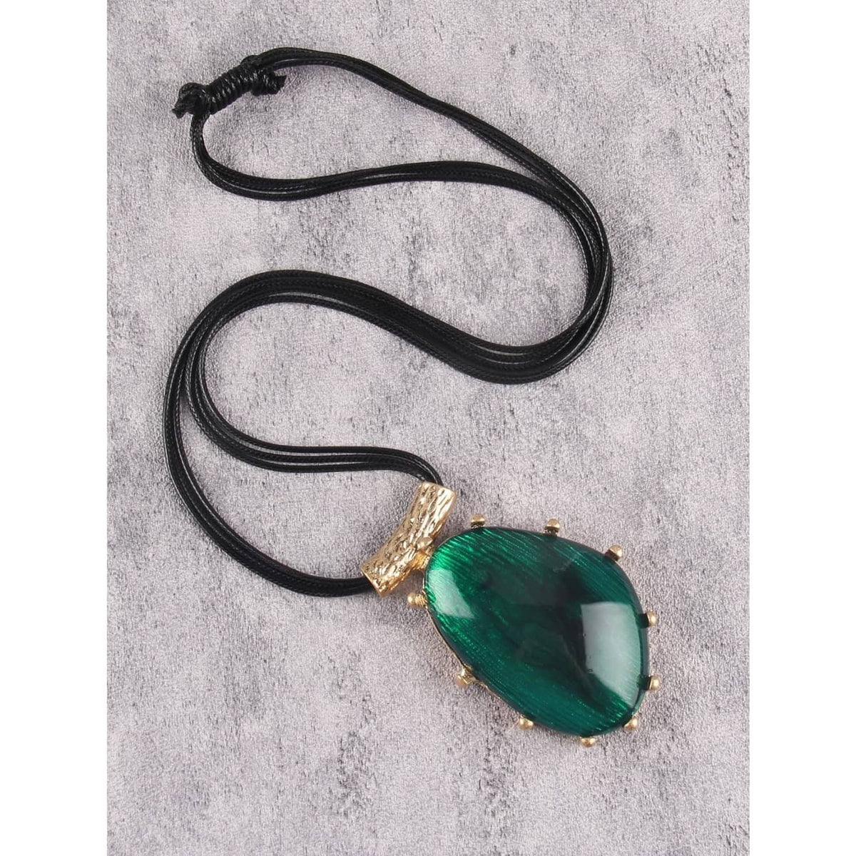 Green teardrop pendant necklace on black faux leather cord with gold bail
