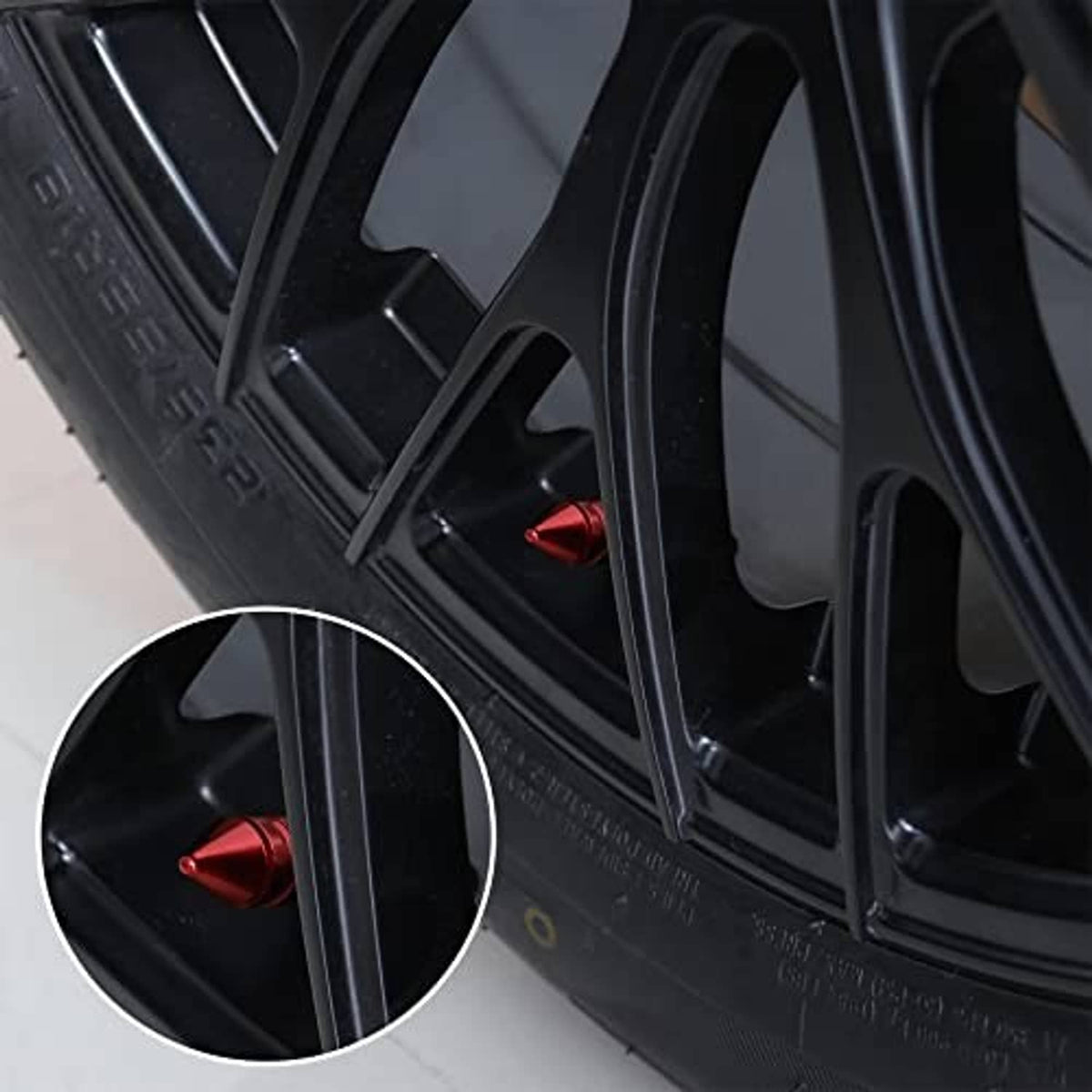Red conical valve cap installed on a black car wheel tire, visible near the rim