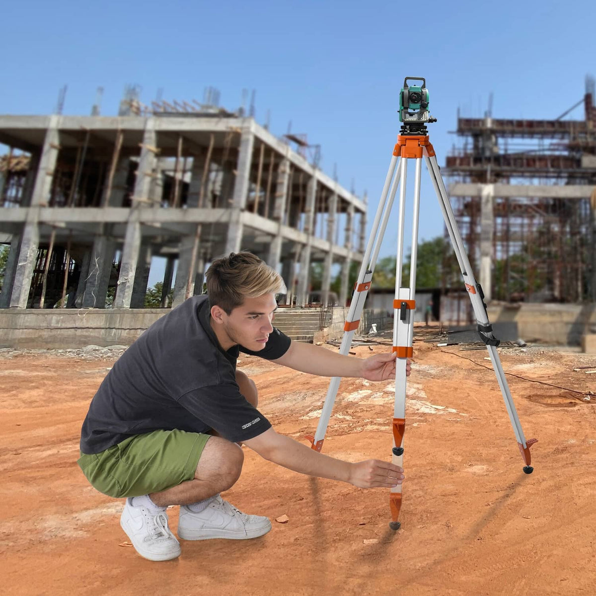 Laser level tripod stand with orange top and silver tripod legs in working position.