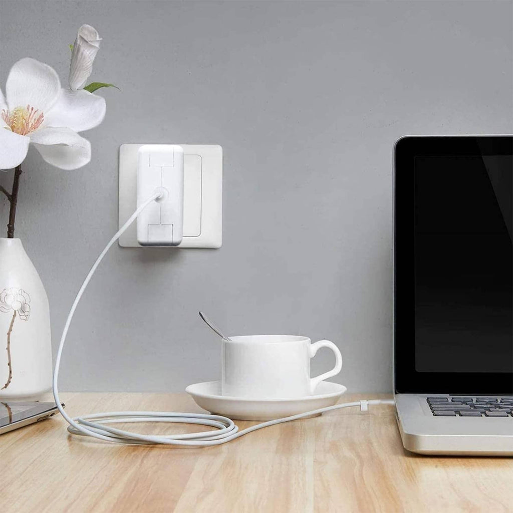 Power adapter charging a laptop from a wall outlet with connected cable