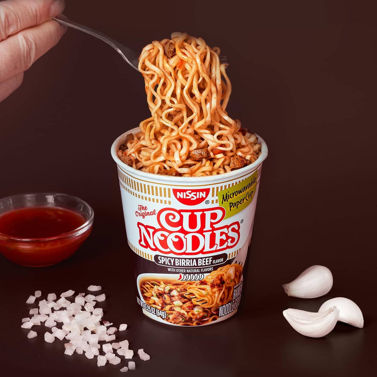Spicy birria beef Cup Noodles cup with noodle strands, chili sauce, and chopped onions