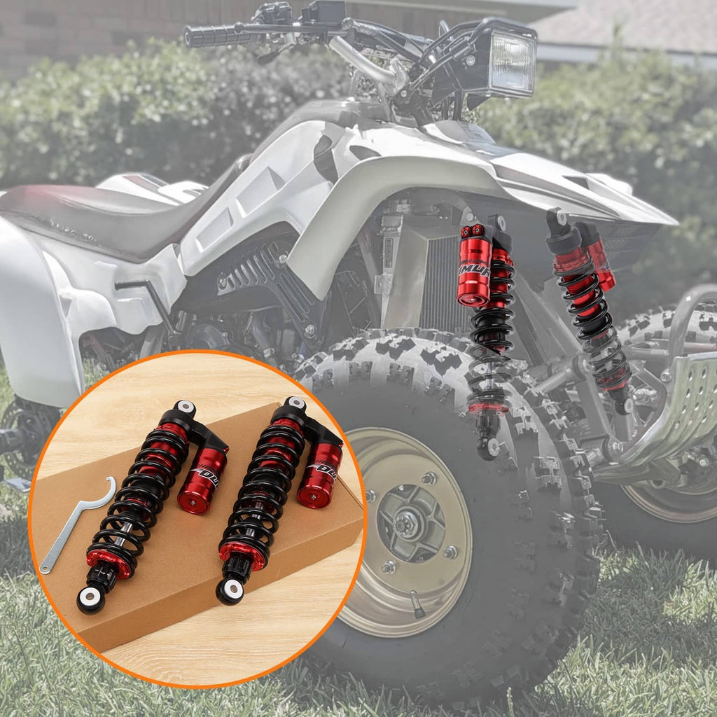 Two red and black front shocks with coil springs near an ATV wheel and fender