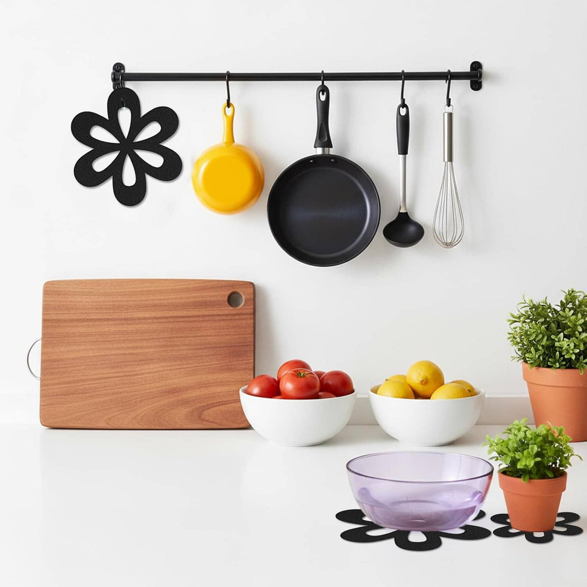 Black flower felt pan protectors shown with cookware on kitchen counter