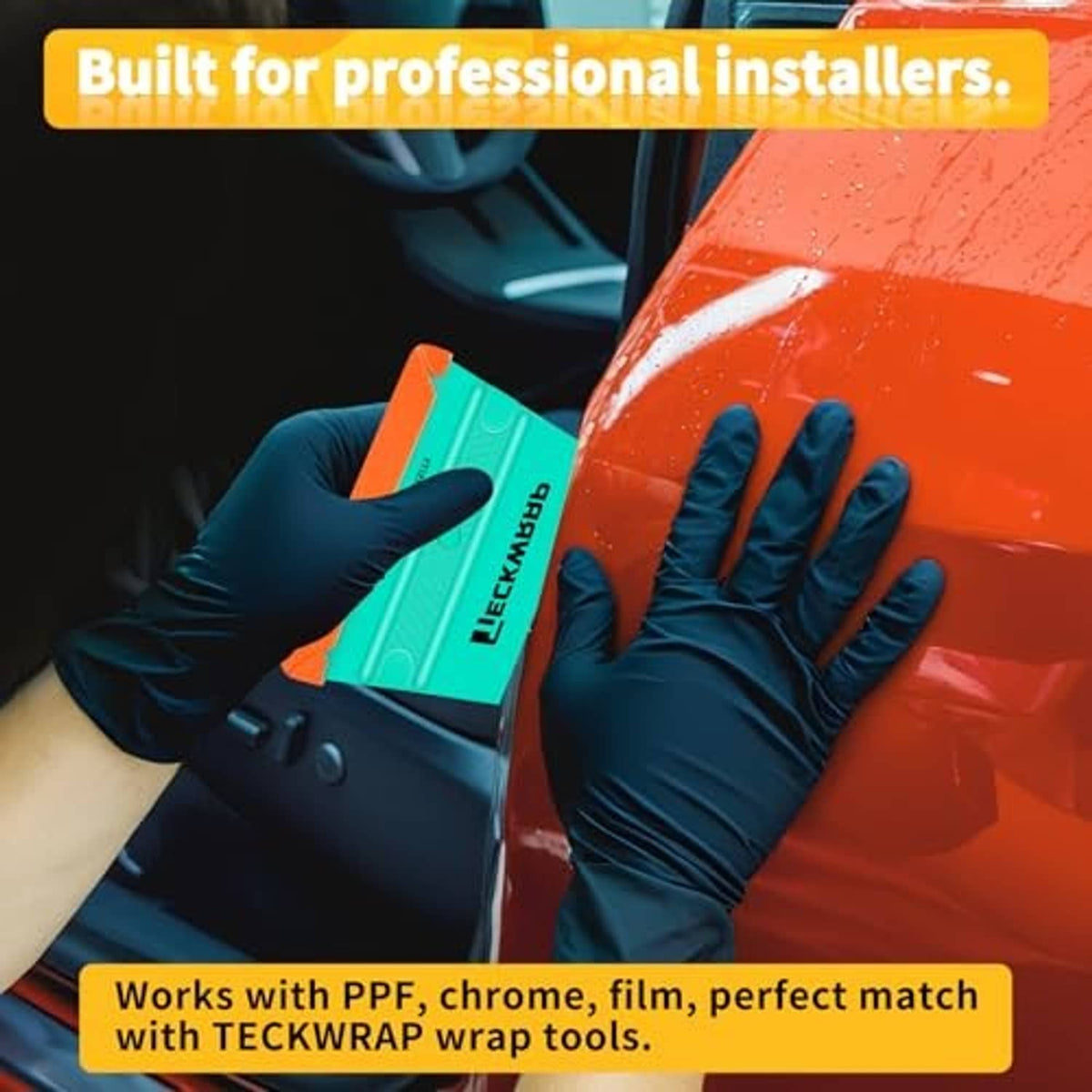 Teal trapezoid felt squeegee pressed to orange car panel with gloved hands.