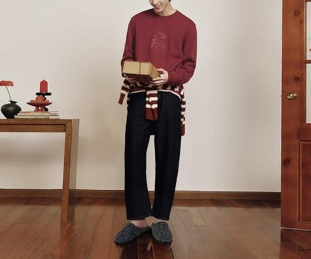 Men's scuff slippers in dark herringbone knit worn with casual pants, closed-toe slip-on.
