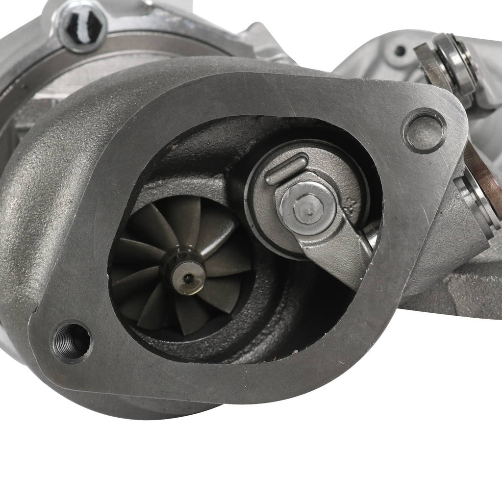 Turbocharger compressor housing close-up with black impeller and mounting bolts