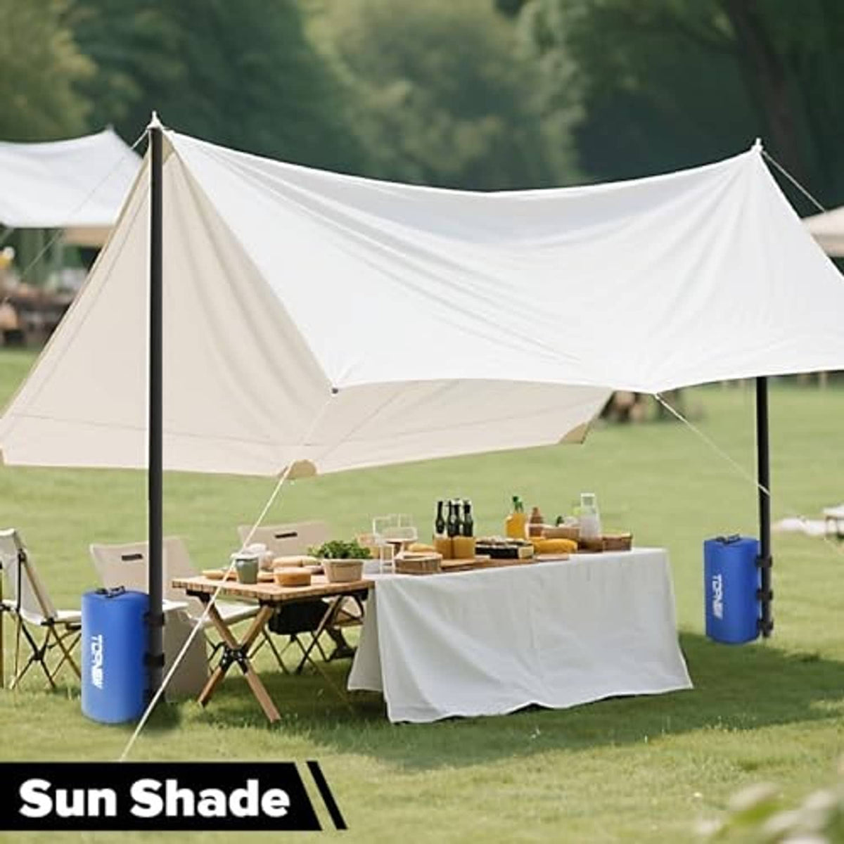 Four blue cylindrical water weight bags anchoring a white canopy tent