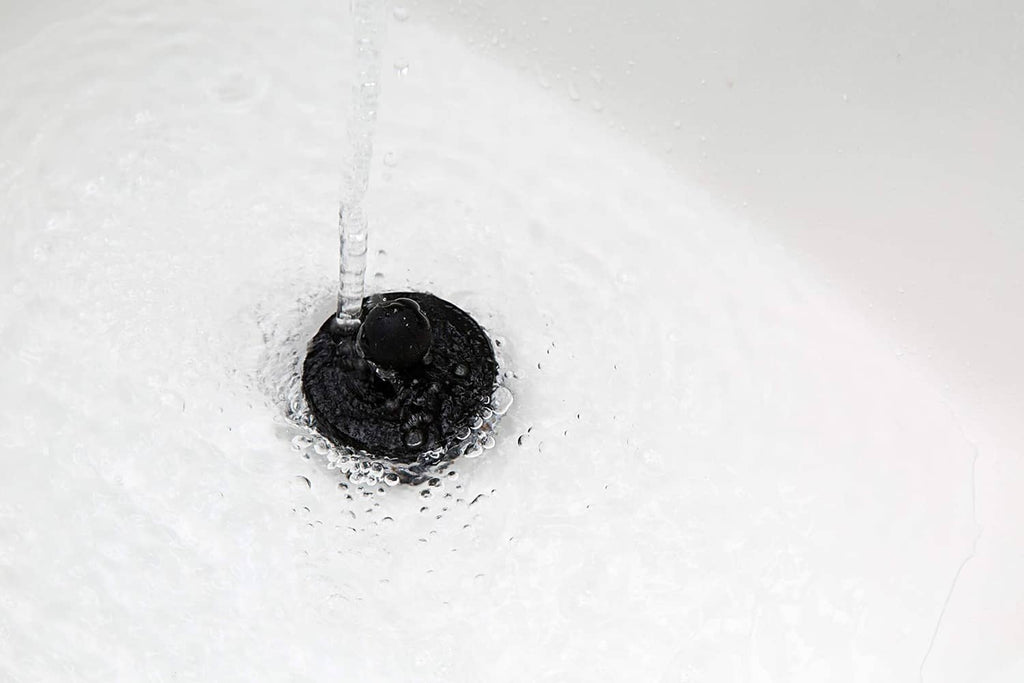 Black universal bathtub stopper plug in tub drain opening, two-pack