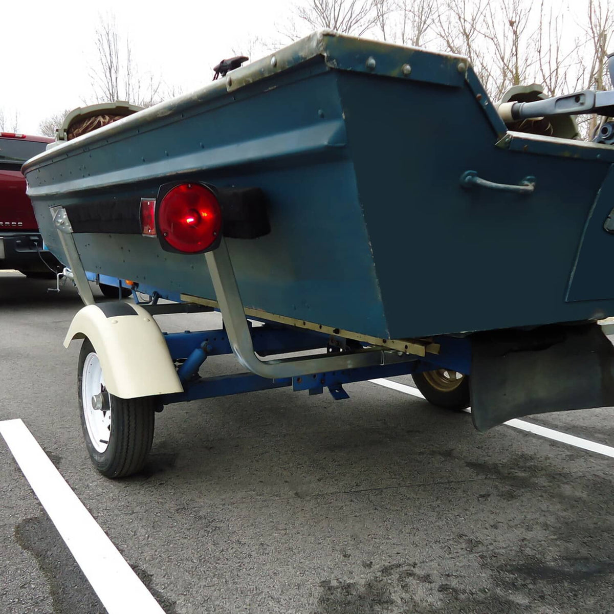 Boat trailer guide assembly on teal trailer frame with black bunk board guide pads